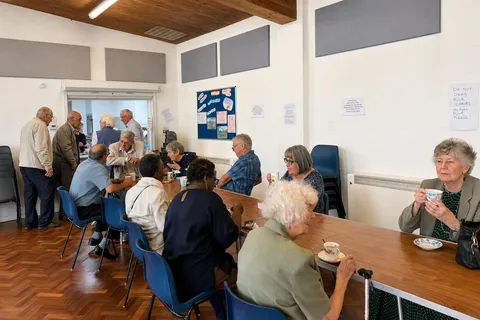 A group of people chatting over tea and coffee at a community coffee morning